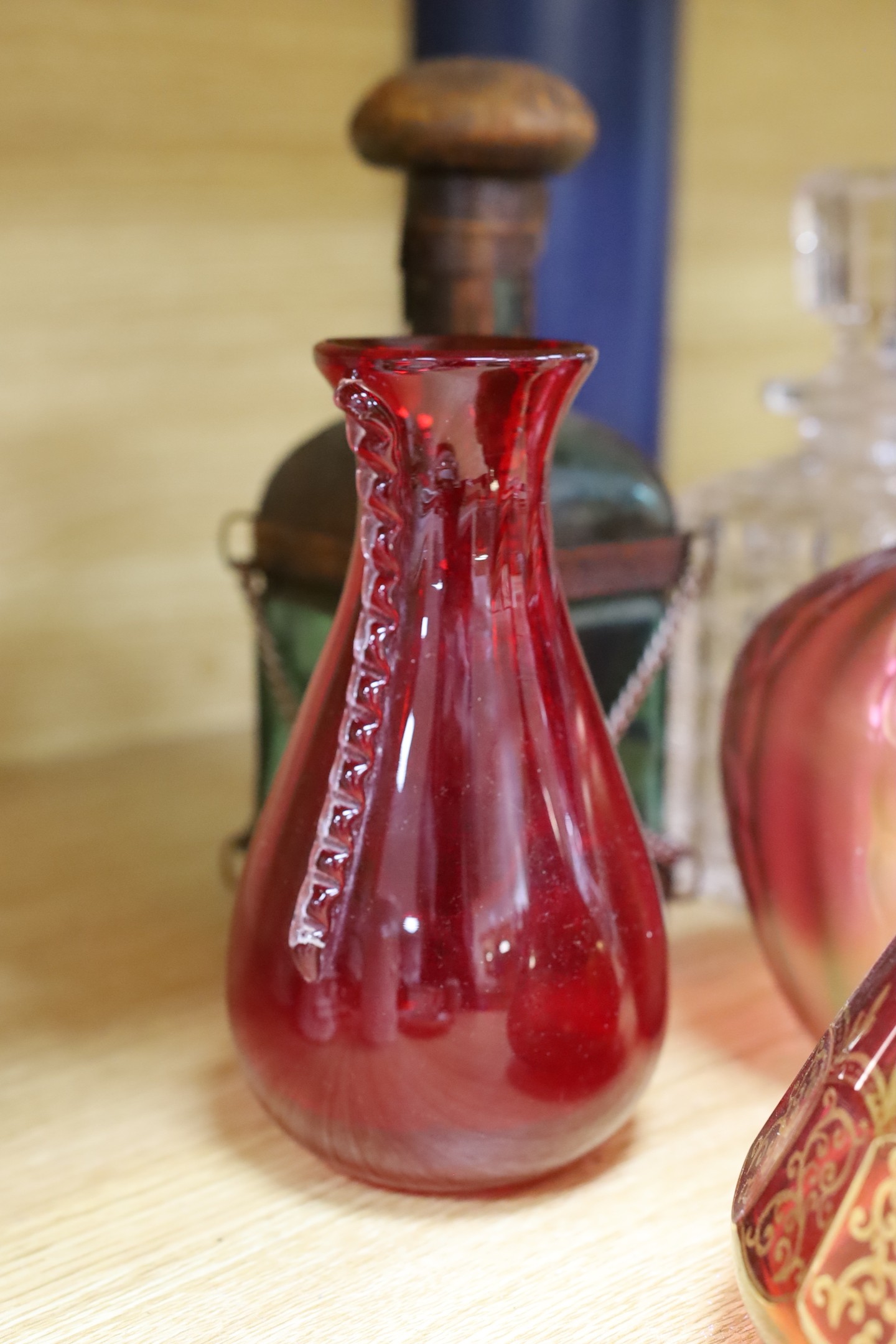 A pair of Bohemian gilded ruby glass decanters and stoppers, a Bohemian ‘millefiori paperweight’ stopper and associated decanter and mixed glass